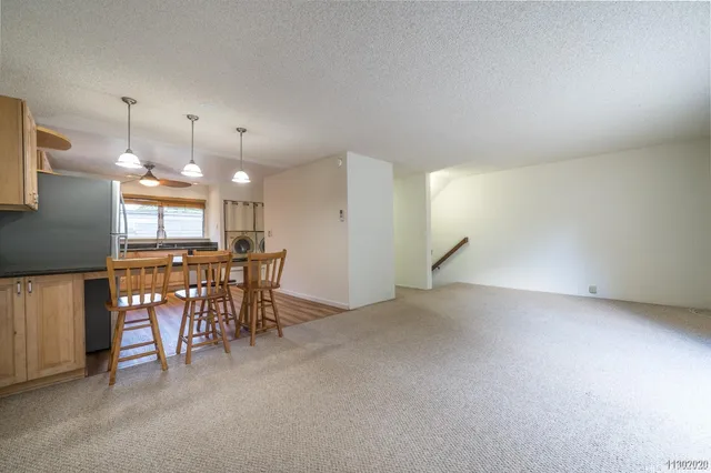 a view of a room with furniture and kitchen view
