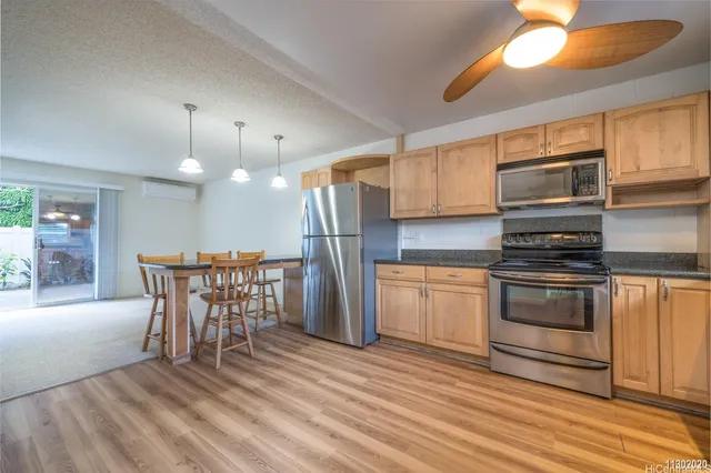a kitchen with stainless steel appliances kitchen island granite countertop a stove a sink and a microwave