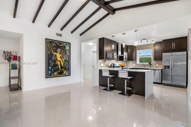 a view of kitchen with kitchen island stainless steel appliances a sink and counter space