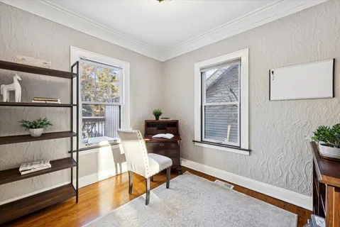a living room with furniture a window and wooden floor