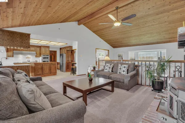 a living room with furniture kitchen view and a large window