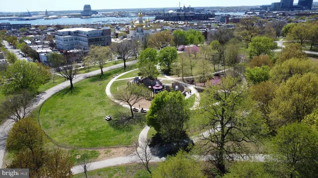 an aerial view of a residential houses with outdoor space and trees