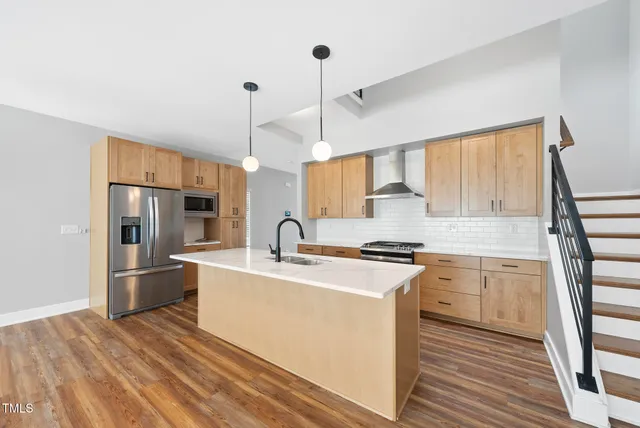a kitchen with stainless steel appliances granite countertop a sink stove and refrigerator