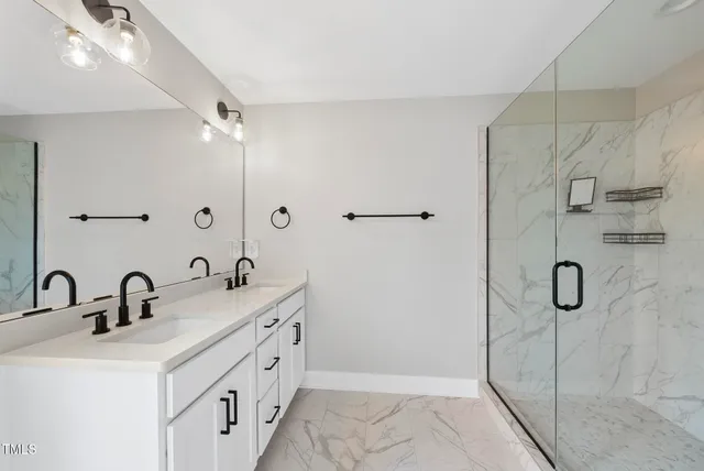 a bathroom with a double vanity sink mirror and shower