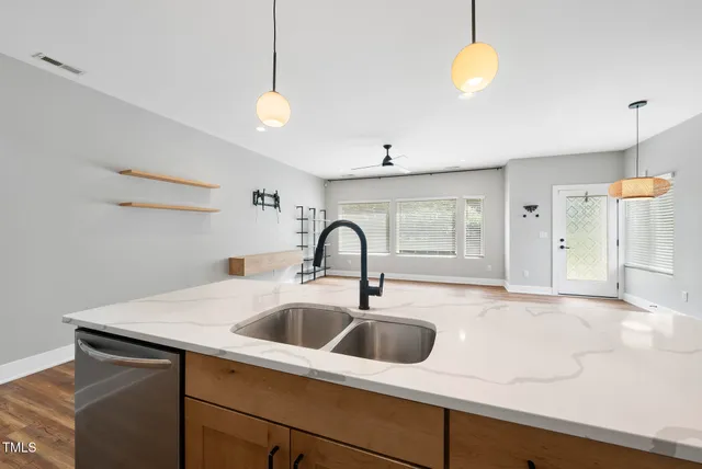 a view of a sink and dishwasher with wooden floor
