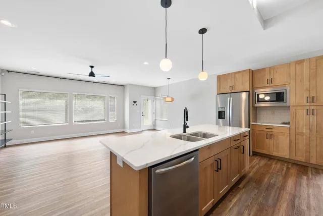 a kitchen with kitchen island a sink stove and wooden floor