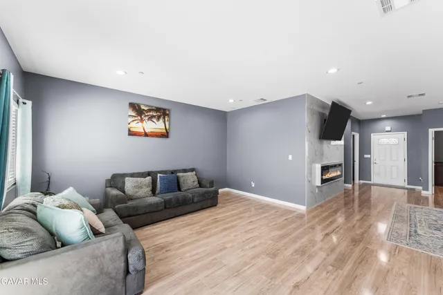 a living room with furniture and a wooden floor