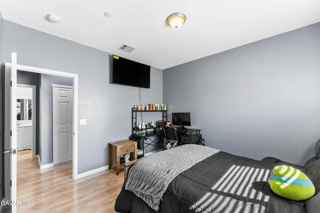 a bedroom with a bed and a flat screen tv