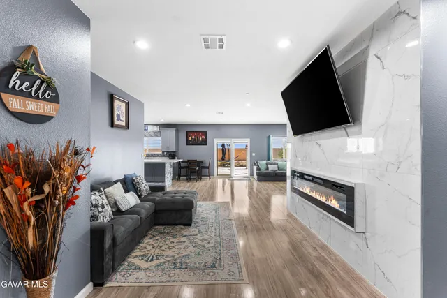 a living room with furniture a flat screen tv and a fireplace