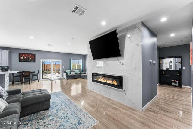 a living room with furniture a flat screen tv and a fireplace