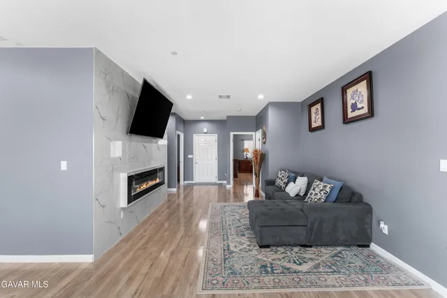 a living room with furniture a fireplace and a flat screen tv