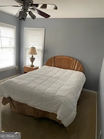 a bed sitting in a bedroom next to a window