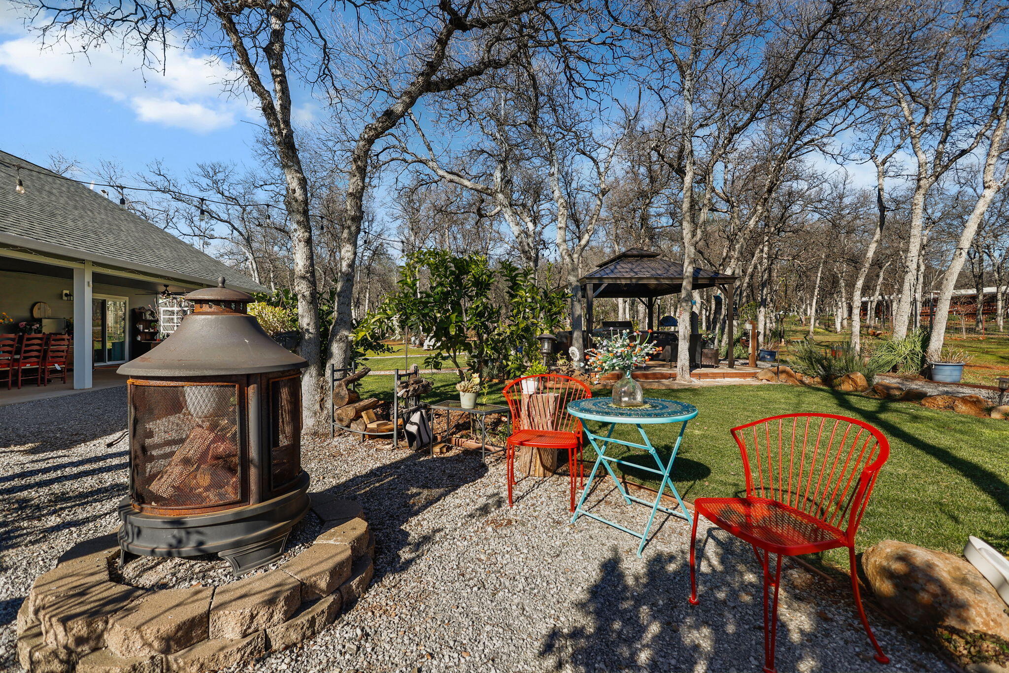 5511 Wilson Hill Road Manton, CA 96059 - Photo 44 of 71 a view of a patio with table and chairs under an umbrella with large trees
