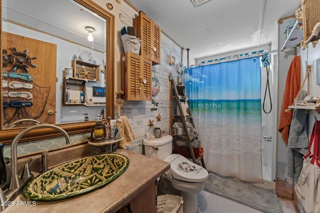 a bed sitting in a bedroom next to a window and a flat screen tv