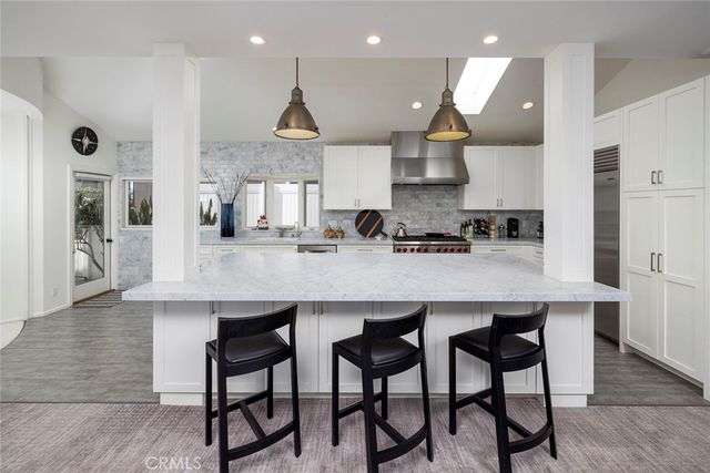 a living room with furniture a rug and kitchen view