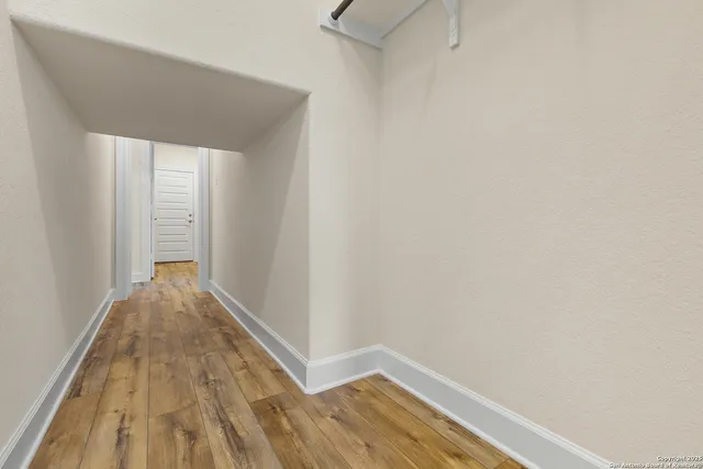 a view of a hallway with wooden floor