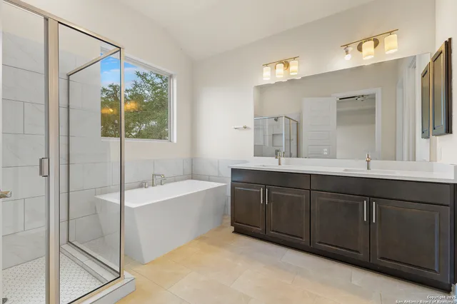 a bathroom with a tub sink and mirror