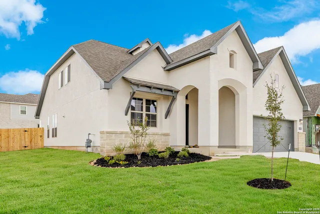 a front view of a house with a garden and plants