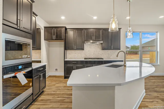 a kitchen with stainless steel appliances granite countertop a sink a stove and a refrigerator