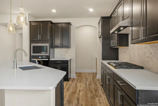 a kitchen with stainless steel appliances granite countertop a sink stove and refrigerator