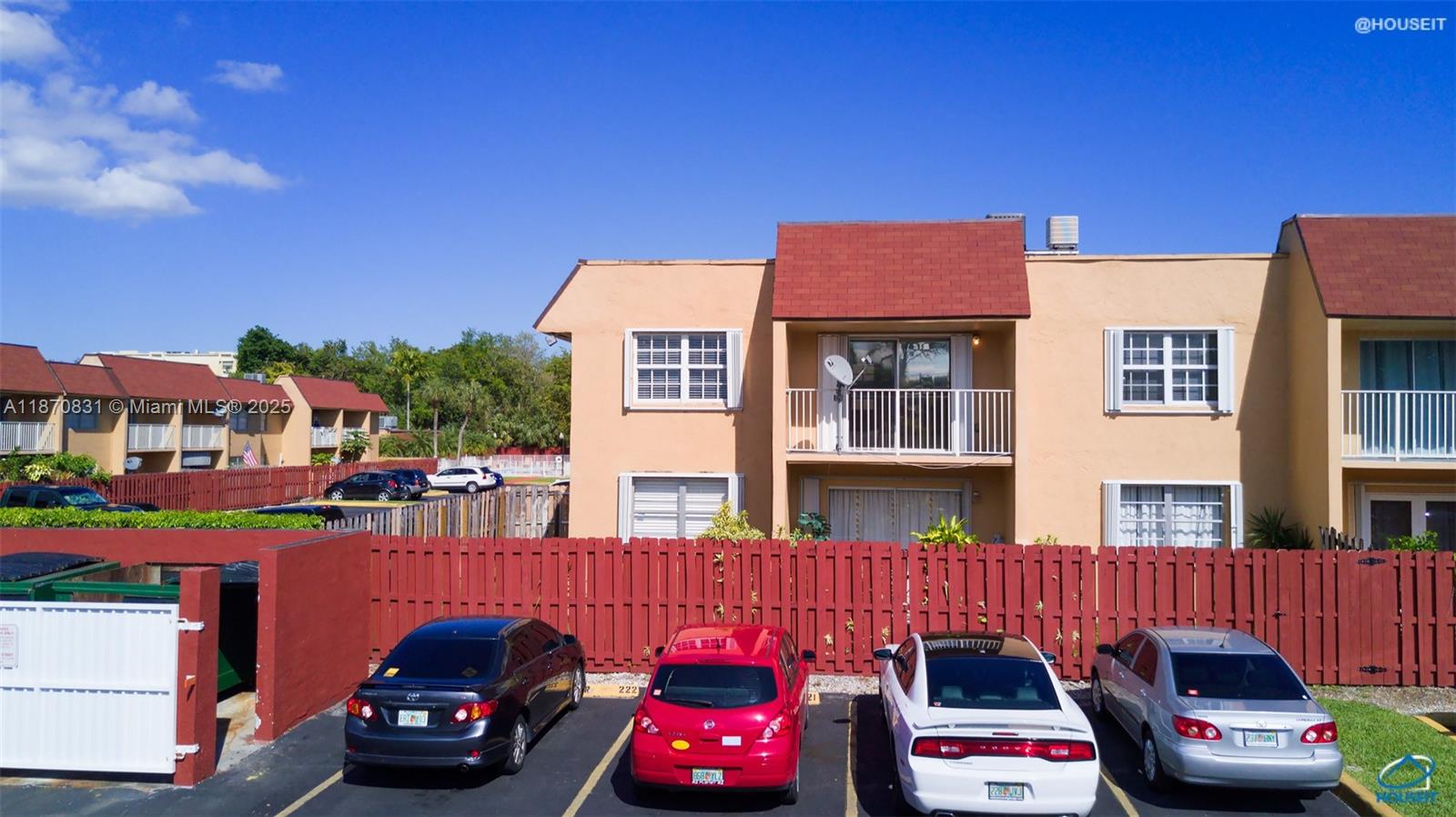 a front view of a building with cars parked