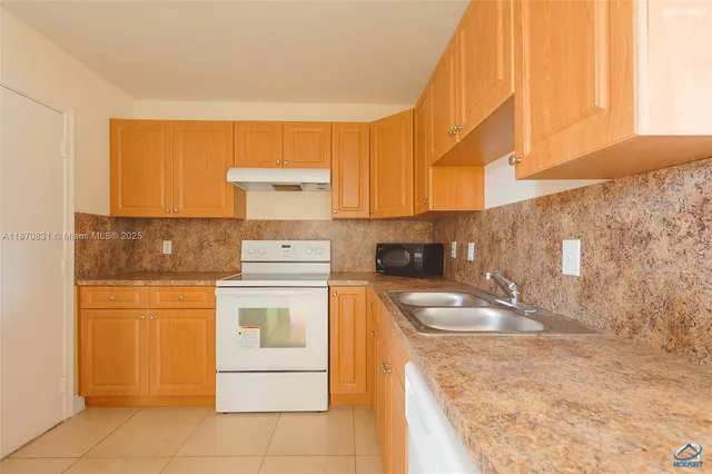 a kitchen with a stove a sink and a refrigerator