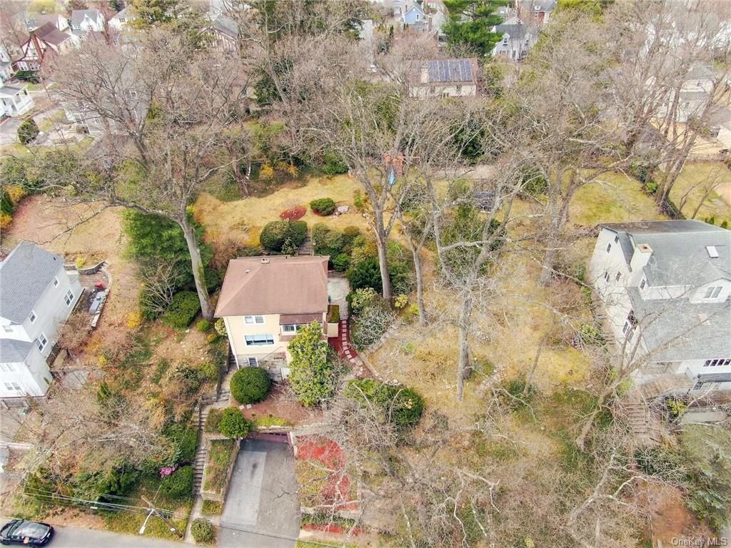 a aerial view of a house with a yard and large trees