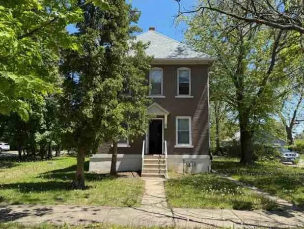 a front view of a house with a garden