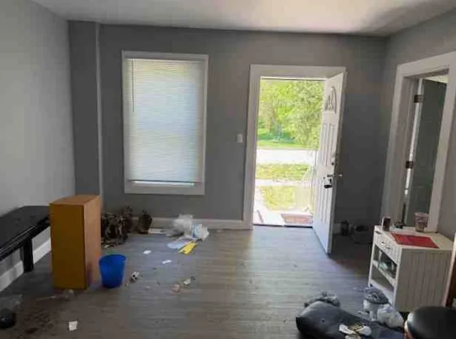 a living room with furniture and a refrigerator