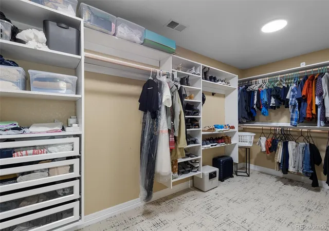 a view of walk in closet with clothes and shoes