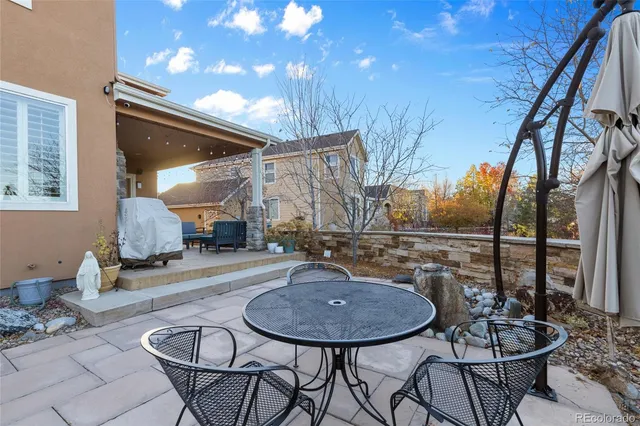 a backyard of a house with table and chairs