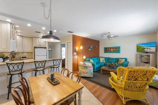 a living room with furniture a chandelier and kitchen view