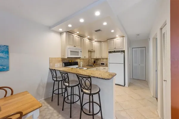 a kitchen with a table chairs refrigerator and microwave