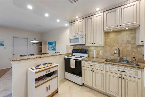 a kitchen with cabinets appliances a sink and a counter space