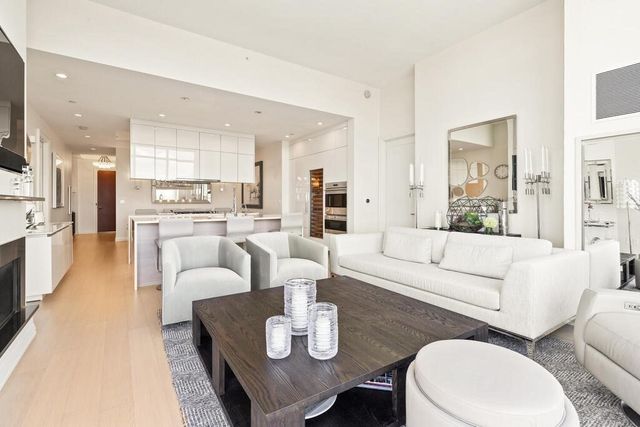a living room with furniture white walls and kitchen view