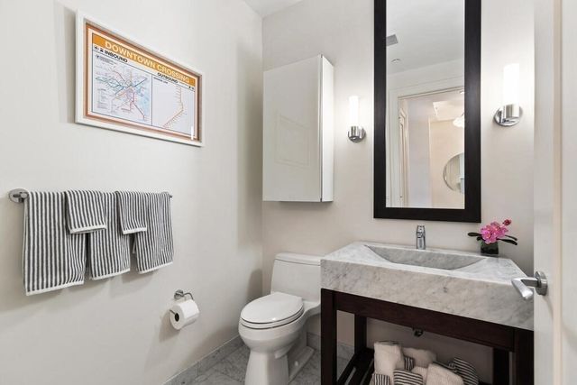 a bathroom with a granite countertop sink mirror and toilet