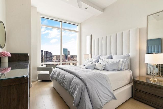 a large bedroom with a bed and a night stand