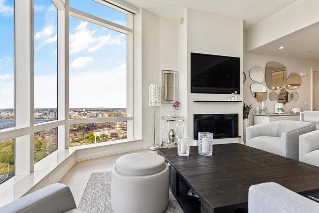 a living room with furniture a flat screen tv and a fireplace