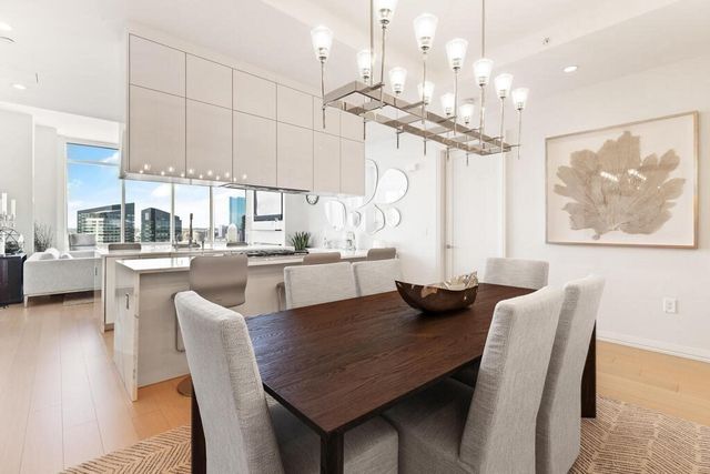 a dining room with furniture a large window and a chandelier