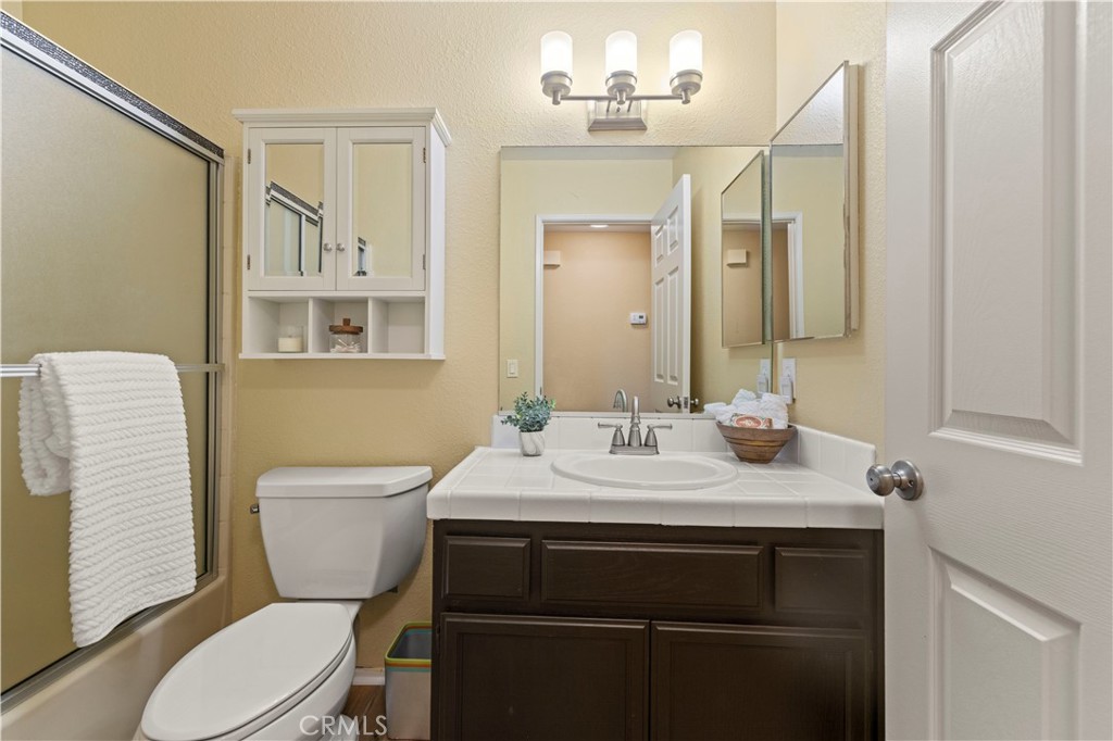 33533 Santiago Road Acton, CA 93510 - Photo 15 of 36 a bathroom with a toilet a sink a mirror a vanity and shower