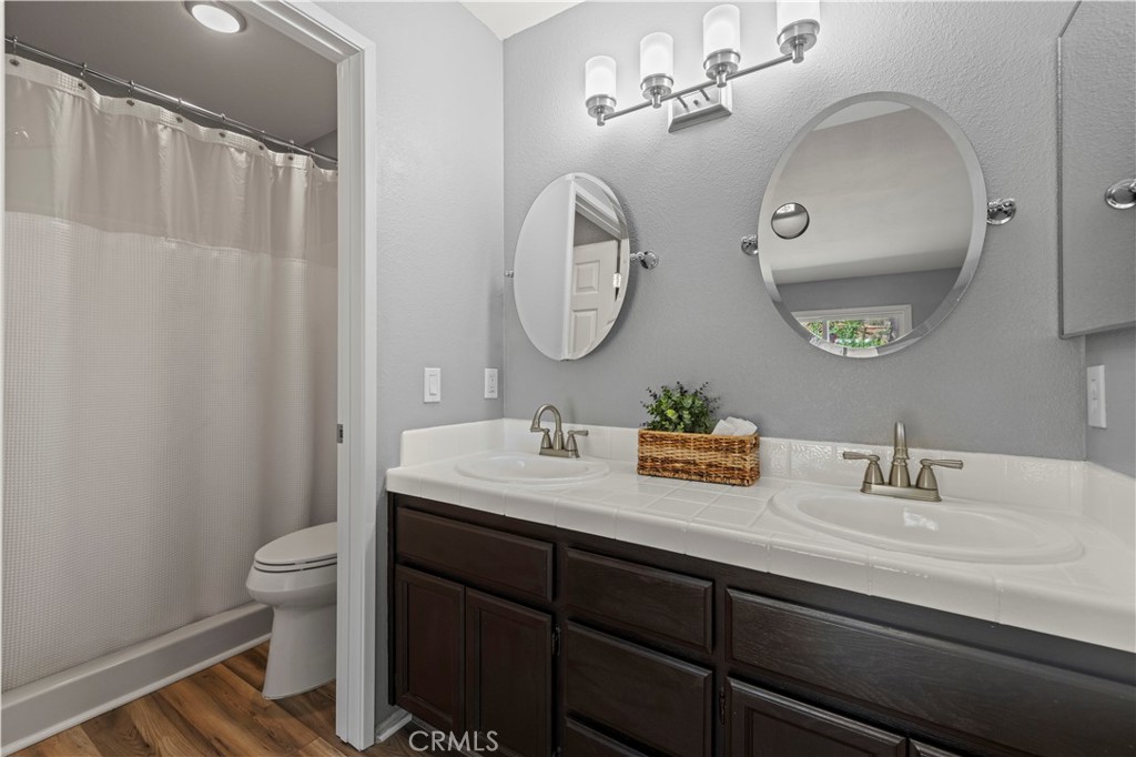 33533 Santiago Road Acton, CA 93510 - Photo 22 of 36 a bathroom with a granite countertop sink a toilet and a mirror