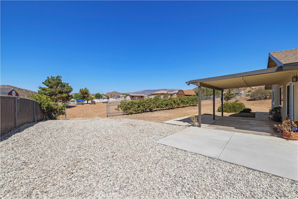 33533 Santiago Road Acton, CA 93510 - Photo 25 of 36 a view of a patio with a table and chairs under an umbrella