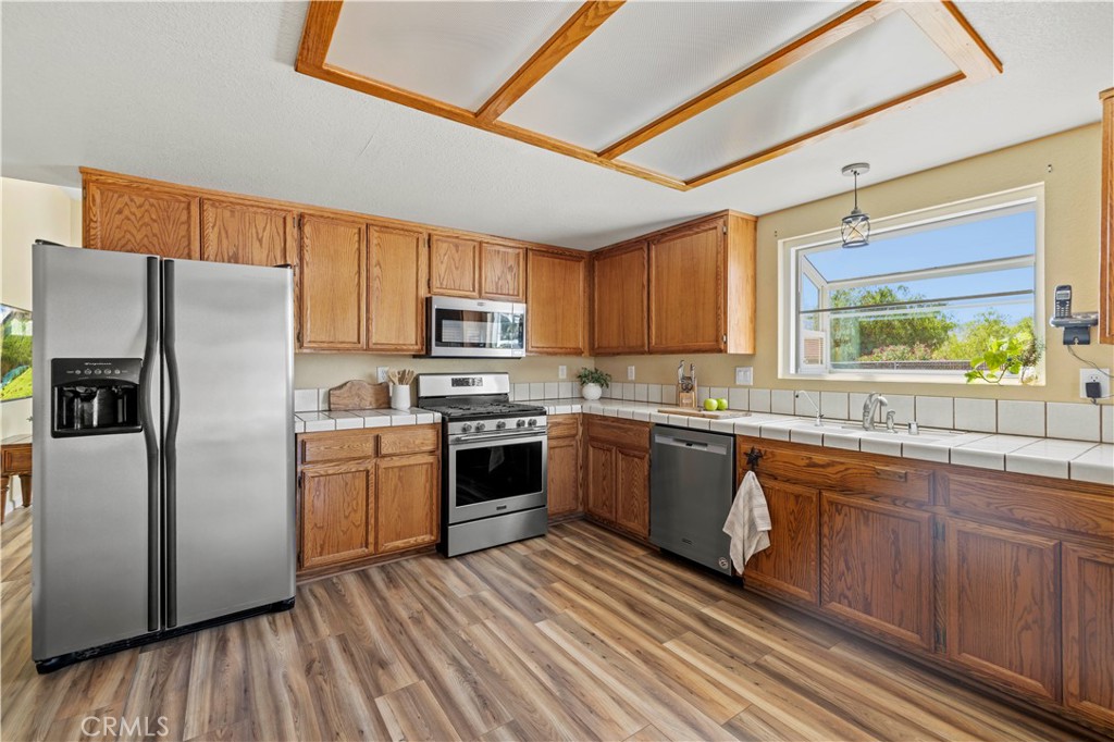 33533 Santiago Road Acton, CA 93510 - Photo 6 of 36 a kitchen with granite countertop wooden floors stainless steel appliances a sink and a window