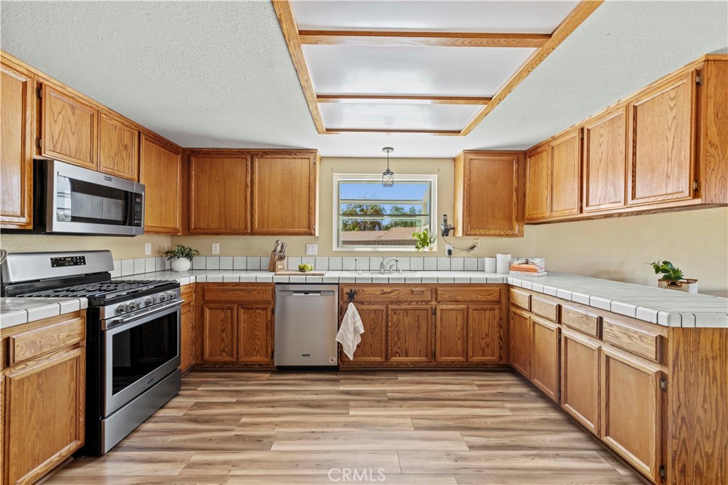33533 Santiago Road Acton, CA 93510 - Photo 7 of 36 a kitchen with stainless steel appliances granite countertop a stove sink microwave and cabinets