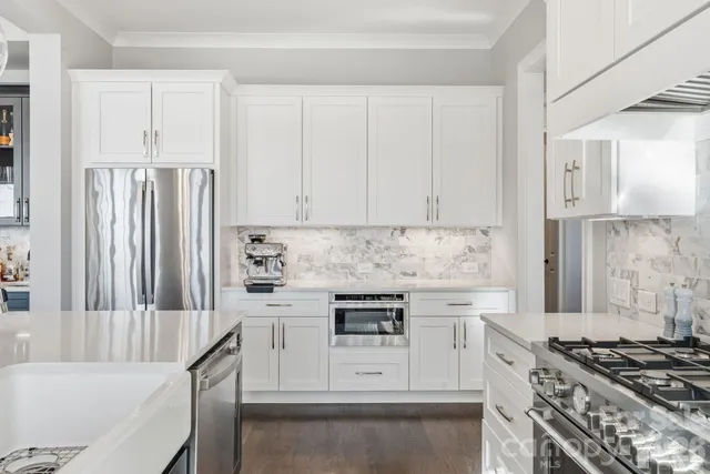 a kitchen with stainless steel appliances white cabinets and stove