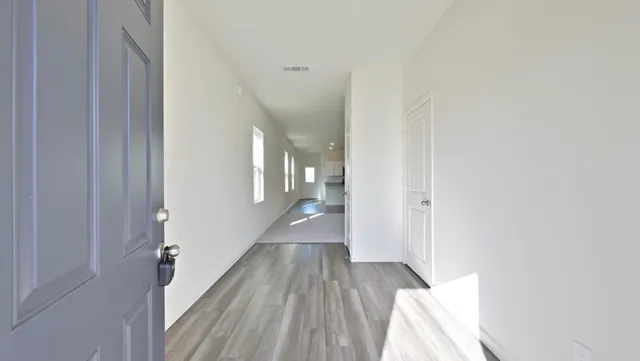 a view of a hallway with wooden floor