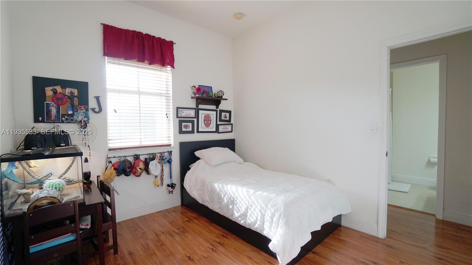 928 Southwest 154th Path, Unit 928 Miami, FL 33194 - Photo 23 of 39 a bed sitting in a bedroom next to a window