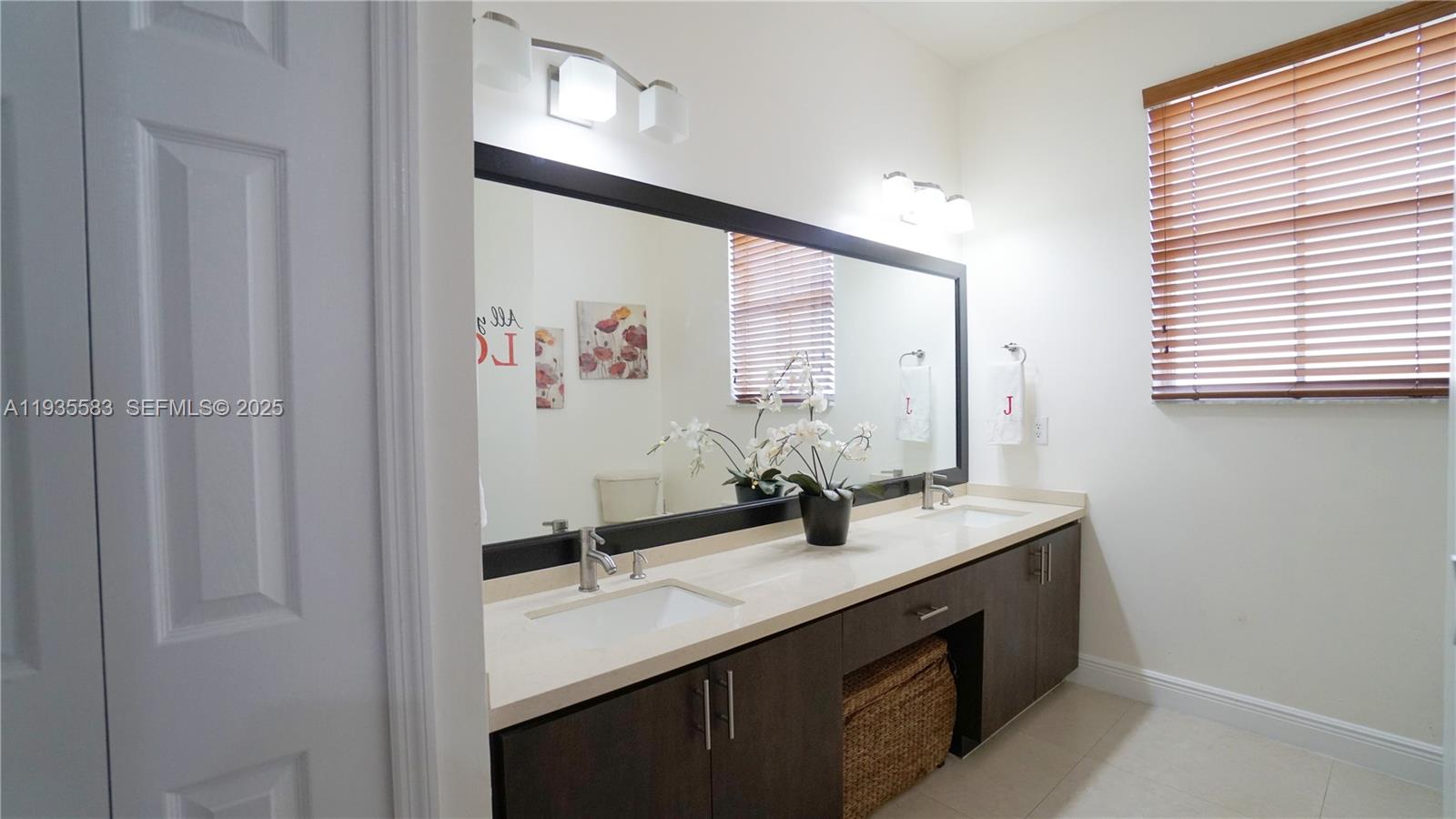 928 Southwest 154th Path, Unit 928 Miami, FL 33194 - Photo 30 of 39 a bathroom with a double vanity sink and a mirror