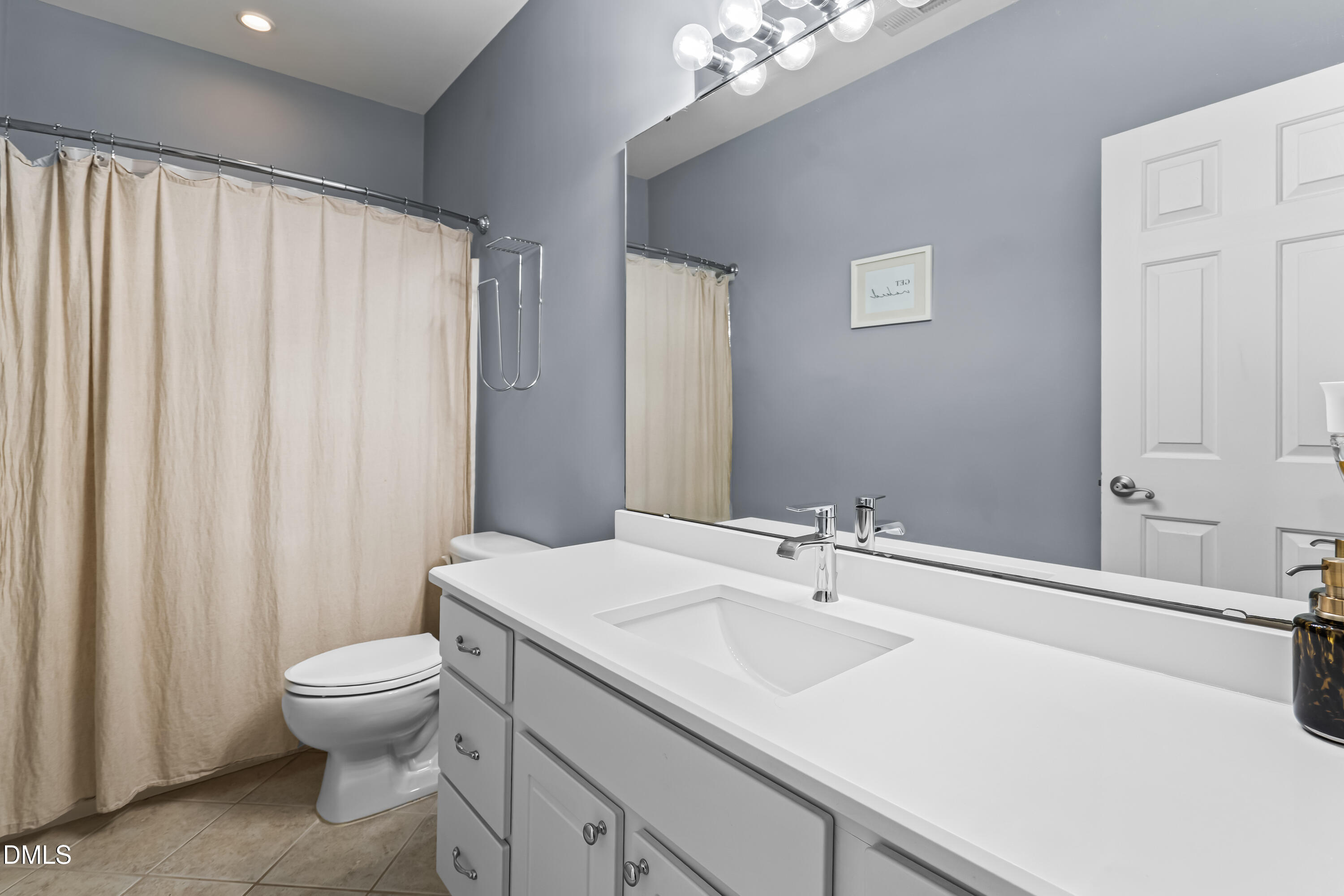 6104 Shandwick Court Raleigh, NC 27609 - Photo 33 of 40 a bathroom with a sink a toilet and shower curtain