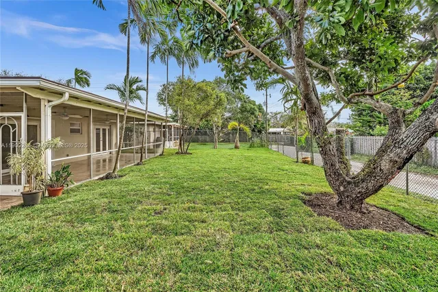 a view of a house with backyard and a tree
